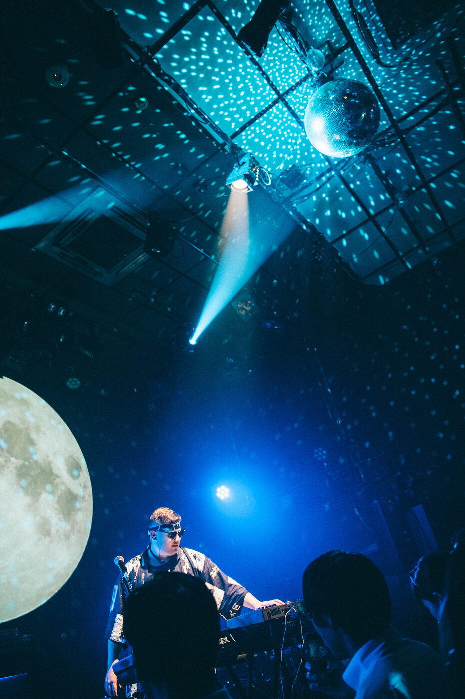 Rob Araujo on stage beneath a giant moon backdrop