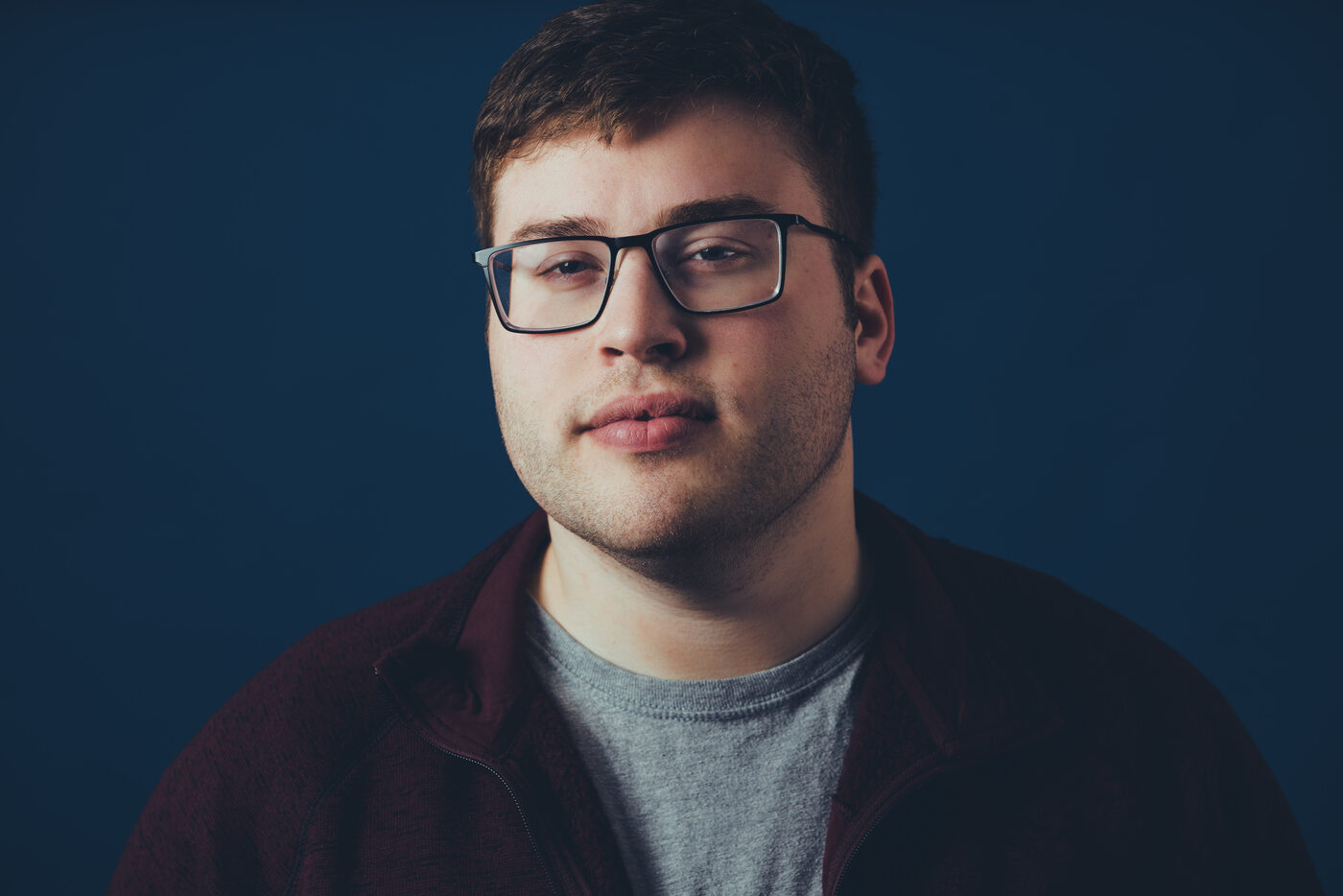 Studio portrait of Rob Araujo on a cobalt backdrop